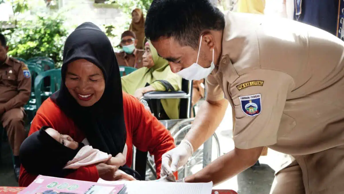 Petugas Posyandu sedang memberikan vaksin pada anak